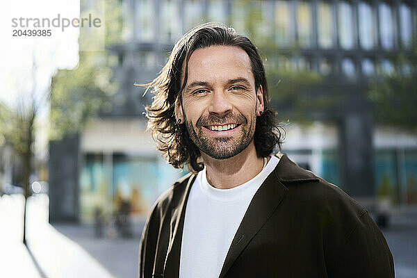 Smiling handsome mature man with stubble wearing jacket