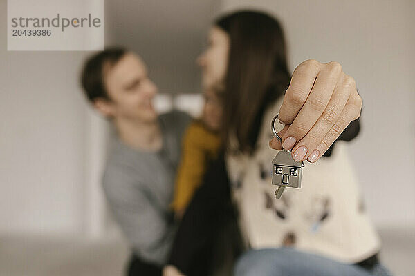 Happy couple holding keys of new apartment