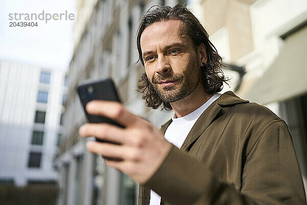 Handsome mature man using smart phone