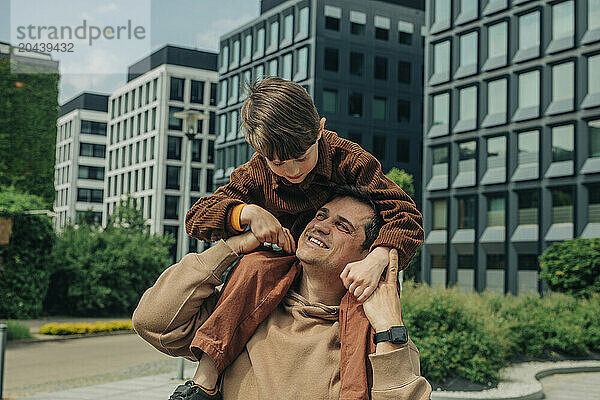 Happy father carrying and enjoying with son in city