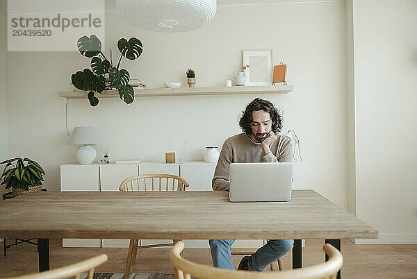 Businessman using laptop at table working from home