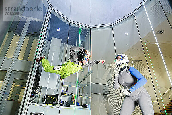 Instructor teaching boy at indoor skydiving center