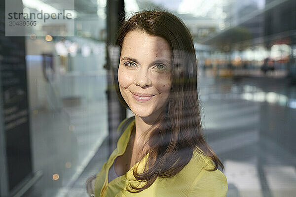 Smiling woman behind glass at airport