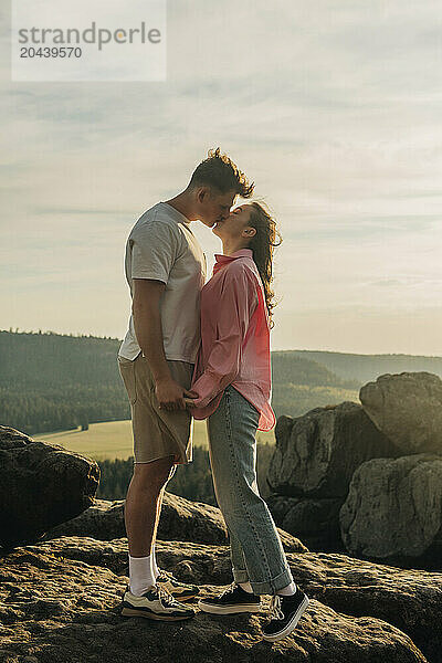 Young couple kissing each other on sunny day