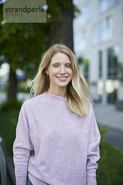 Smiling blond woman wearing purple sweater