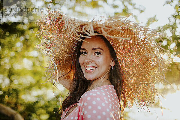 Happy beautiful woman wearing straw hat