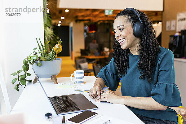 Smiling businesswoman doing video call through laptop at office