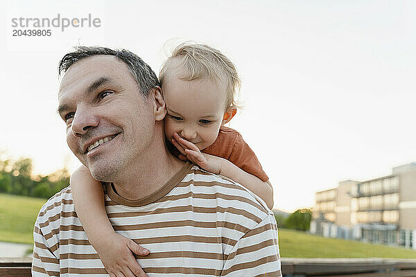 Happy father with son embracing in park