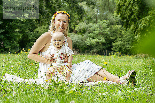 Happy mother sitting with son in garden