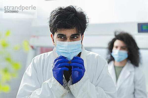 Scientist wearing surgical mask and glove in laboratory