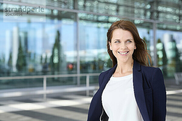 Happy businesswoman standing at airport