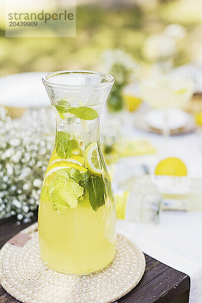 Lemonade with fresh lemons and mint leaves in jug