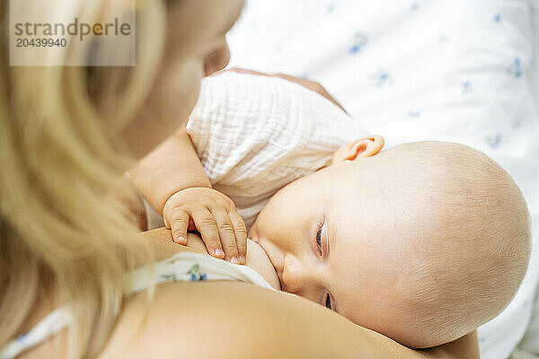 Mother breastfeeding son in summer