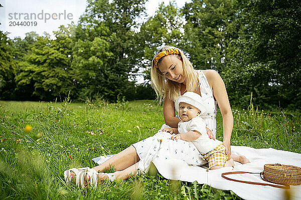 Mother and son sitting on blanket in garden