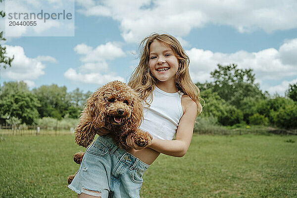 Happy girl with Maltipoo dog in farm