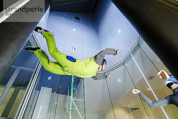 Young man learning skydiving at indoor skydiving center