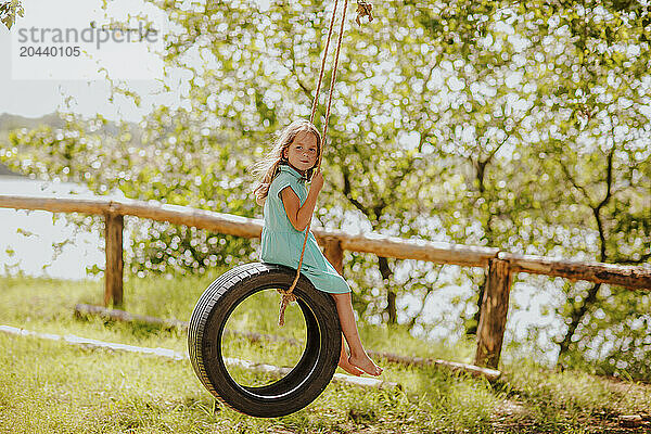 Girl swinging on tire at garden