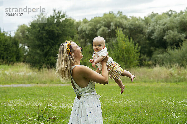 Happy mother holding son in garden