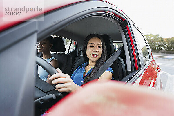 Woman driving car sitting with friend