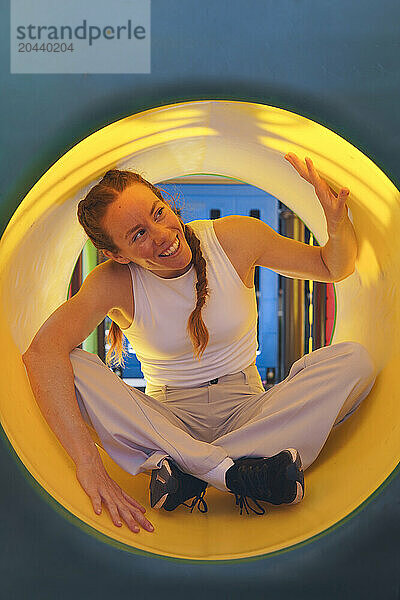 Happy woman sitting inside slide