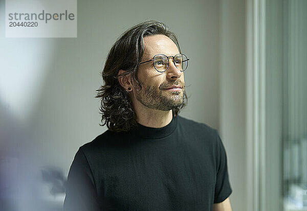 Thoughtful businessman standing at office