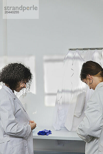 Young scientists wearing white lab coats at laboratory