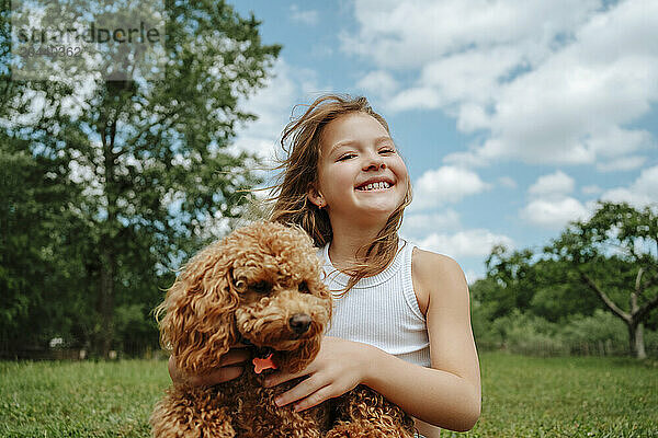 Smiling girl with Maltipoo dog in farm