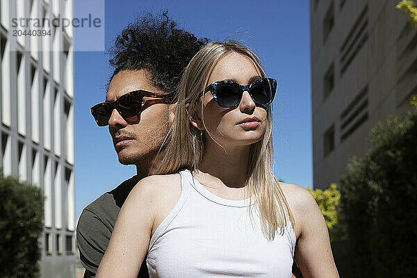 Young man and woman wearing sunglasses on sunny day