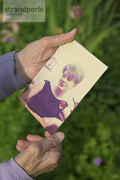 Senior woman holding photography at field