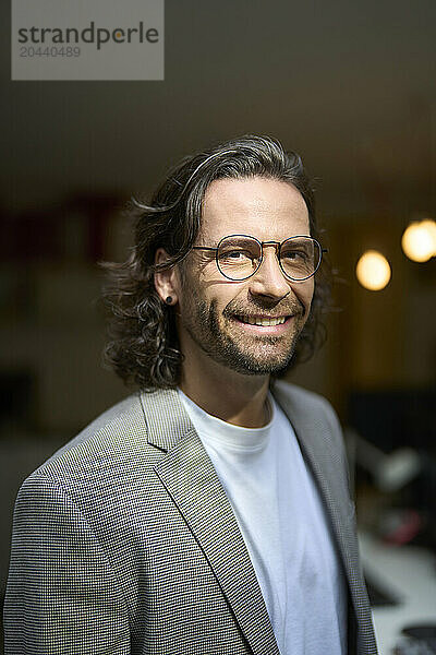 Smiling handsome mature businessman wearing eyeglasses at office