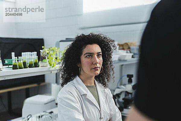 Scientist with curly hair in biology laboratory