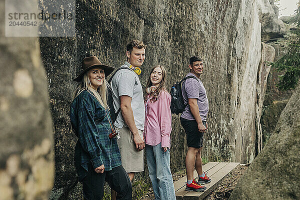 Smiling couples standing together near rocks