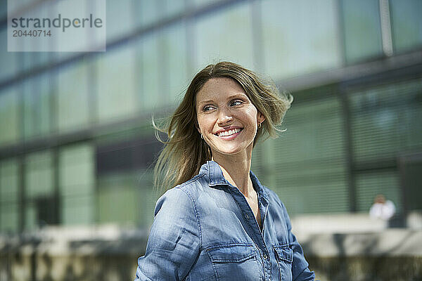 Happy woman walking in front of building