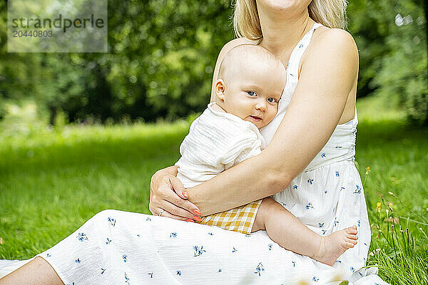 Mother embracing son sitting in garden