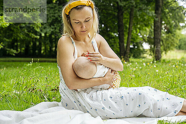 Mother breastfeeding son in garden