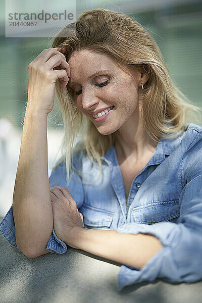 Smiling shy woman leaning on elbow