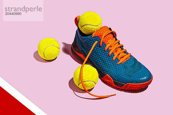 Padel sport shoe and tennis ball on pink background