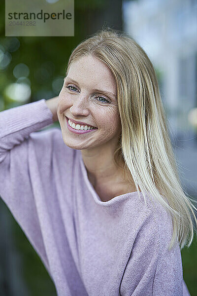 Smiling woman with blond hair and wearing purple sweater