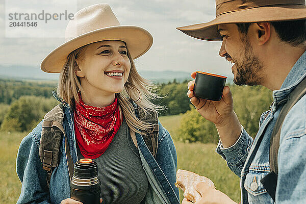 Smiling man enjoying tea with friend on vacation