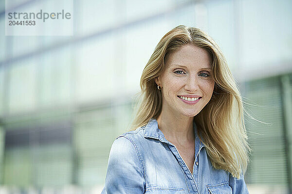 Smiling blond hair woman wearing denim shirt