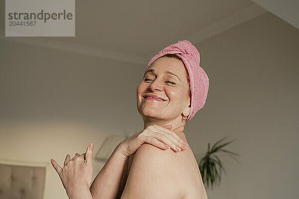 Happy woman massaging shoulder at home