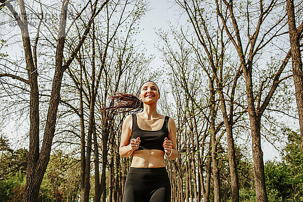 Smiling woman running in park