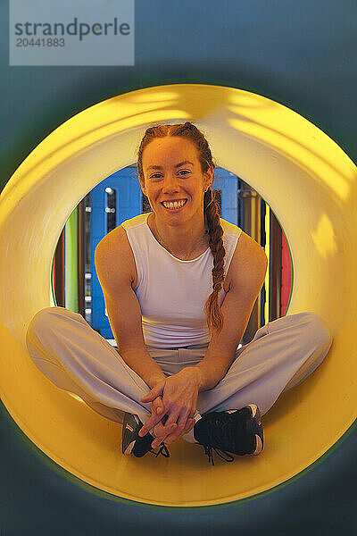 Smiling woman sitting inside slide