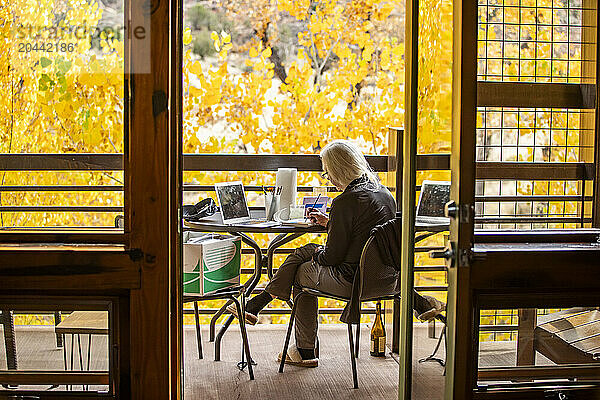 Woman painting with watercolors on porch in autumn