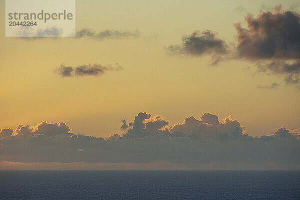 Clouds above calm ocean at sunrise