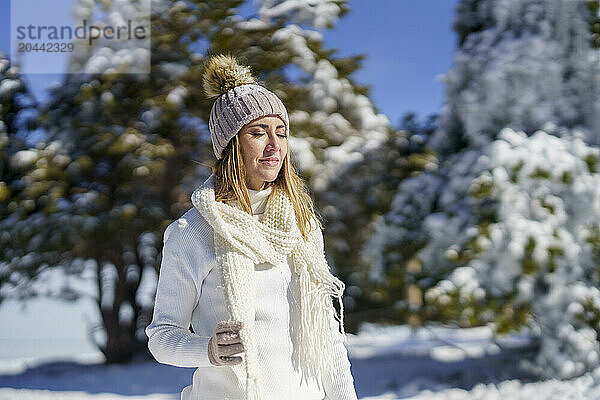 Smiling woman with eyes closed standing in winter snow