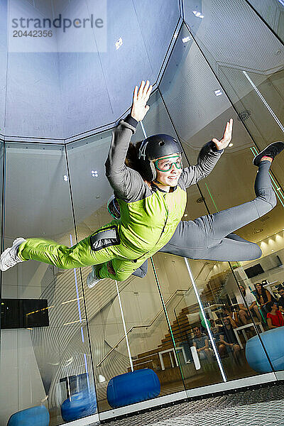 Cheerful girl enjoying at indoor skydiving center