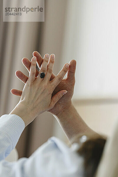 Loving couple holding hands at home