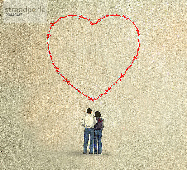 Couple looking at barbed wire heart