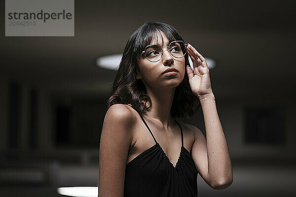 Thoughtful woman with bangs wearing eyeglasses